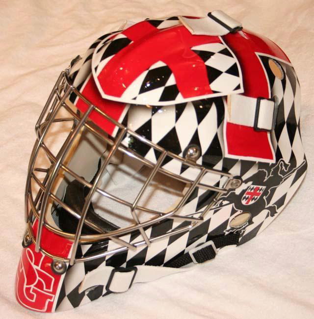 Hockey goalie mask with checkered and red designs.