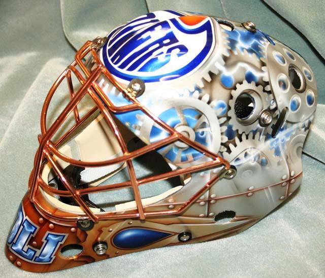 Custom hockey goalie mask with Edmonton Oilers logo and intricate design.