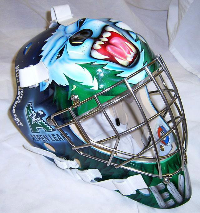 A detailed ice hockey goalie mask with fierce animal artwork and protective cage.