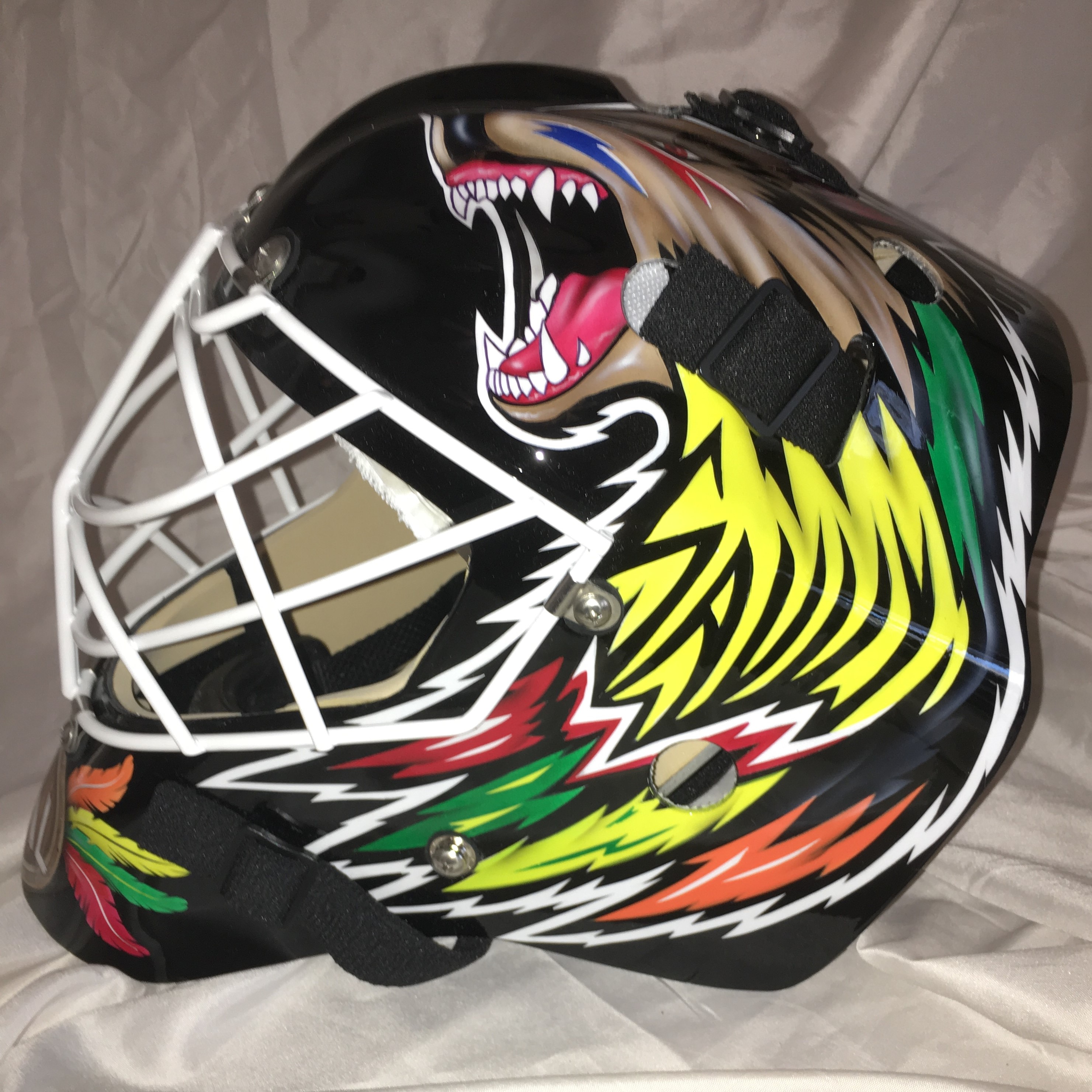 Colorful hockey goalie mask featuring a roaring bear design.