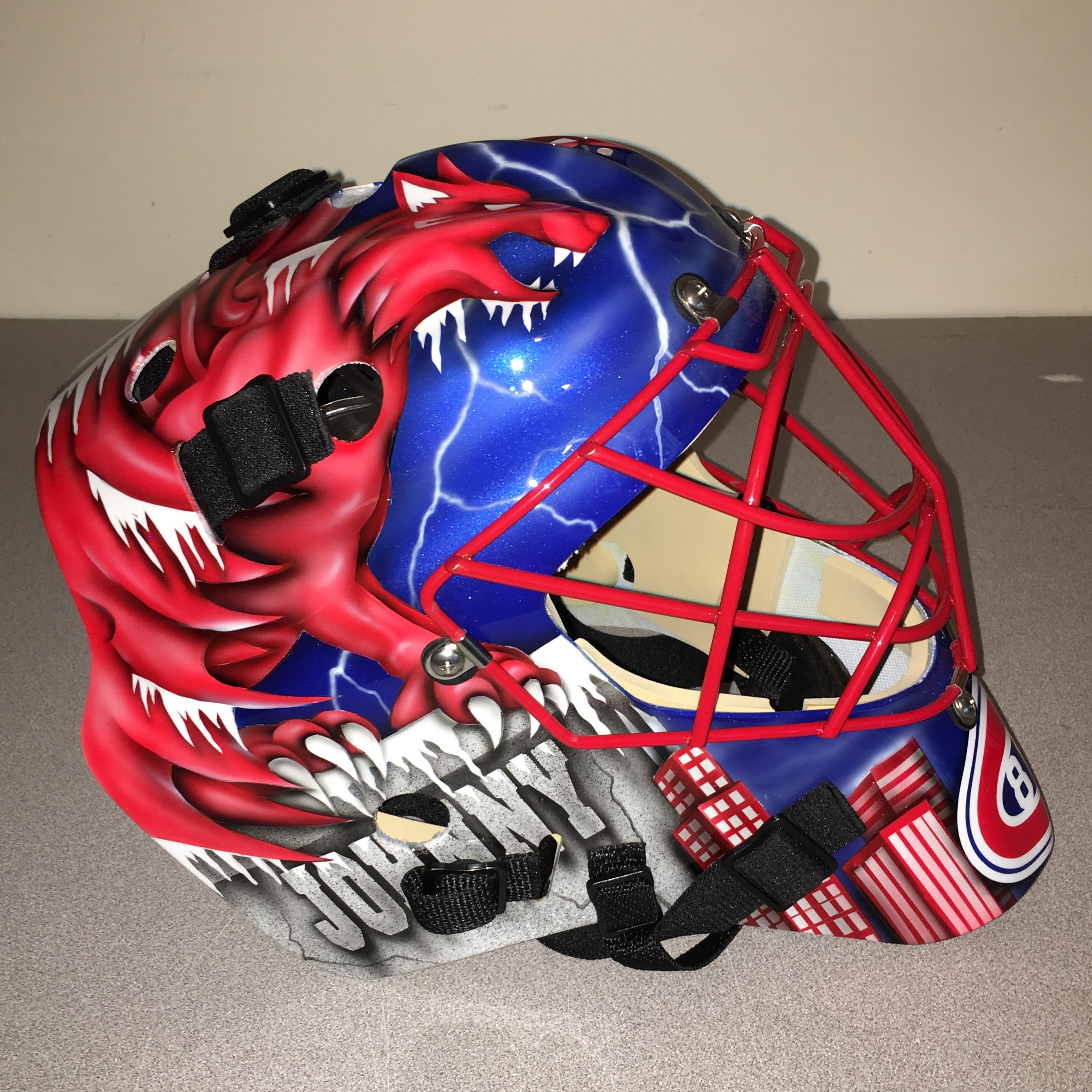 Custom hockey goalie mask with red, blue, and white dragon design.