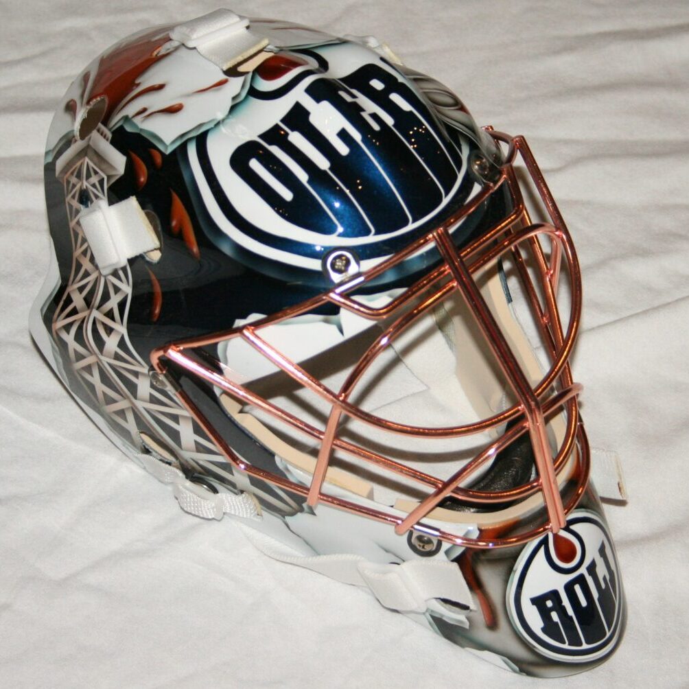 A detailed Edmonton Oilers goalie mask with intricate designs and logos.